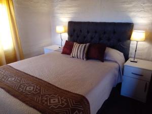 1 dormitorio con 1 cama grande y 2 lámparas en Finca Mula en Maipú