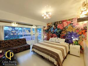 sypialnia z łóżkiem i kwiatową ścianą w obiekcie Hotel Temático Casa Puebla w mieście Puebla