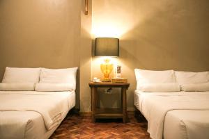 2 camas en una habitación con una lámpara en una mesa en CASA Artist Room Rental San Antonio Zambales, en Subic