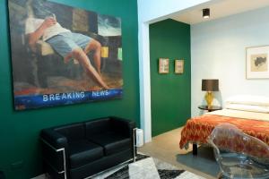 um quarto com uma cama, um sofá e um quadro em CASA Artist Room Rental San Antonio Zambales em Subic