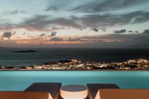 a pool with a view of a city and the ocean at Lovia Mykonos in Mikonos