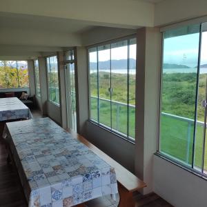 a room with windows with a view of the ocean at Pousada Pegadas na Areia in Palhoça