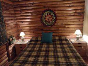 Un dormitorio con una cama y dos mesitas de noche con lámparas. en Cabaña Sonnentahl 2, en Potrerillos