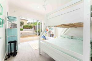 a bedroom with a bunk bed and a large window at Boomer Beach Retreat- Pet and Family Friendly in Port Elliot