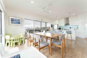a kitchen and dining room with a table and chairs at Boomer Beach Retreat- Pet and Family Friendly in Port Elliot