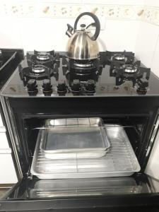 a tea kettle is sitting on top of an oven at Triplex ideal para grupos. Acomoda mais de 20. in Curitiba +16 photos