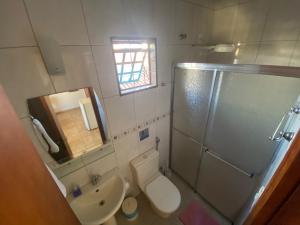 a bathroom with a toilet and a shower and a sink at Chico de Sá Pousada in Pirenópolis +37 photos