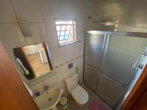 a bathroom with a toilet and a shower and a sink at Chico de Sá Pousada in Pirenópolis