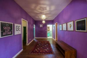 a hallway with a purple wall with a bench and a rug at The Chillhouse Canggu by BVR Bali Holiday Rentals in Canggu