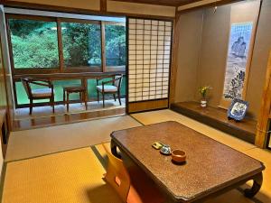 een Japanse kamer met een tafel en een eetkamer bij Shokinkan in Yasugi