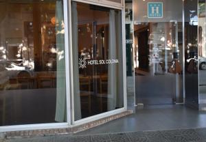 a glass door of a store with a sign on it at Hotel Sol Colonia in Colonia del Sacramento