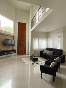 uma sala de estar com um sofá e uma televisão em AMPLA CASA DE CAMPO - MORADA DA SERRA em Aguas Mornas