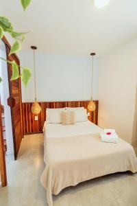 a bedroom with two beds and two lights at Apartamento Manay in Jericoacoara