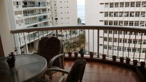- Balcón con mesa, sillas y edificios en Apê da Mi - 2 min da Praia de Pitangueiras - Guarujá, en Guarujá