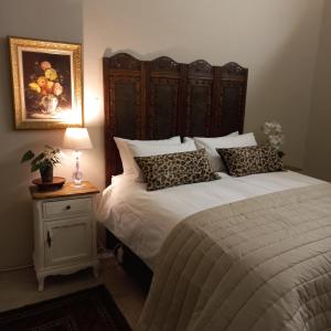 um quarto com uma cama e uma mesa com um candeeiro em Bowden B&B em Olifantshoek