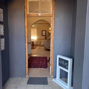um corredor com uma porta que leva a uma sala de estar em Bowden B&B em Olifantshoek