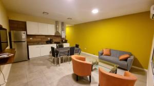 cocina y sala de estar con sofá y sillas en Pirkas Departamentos, en San Juan