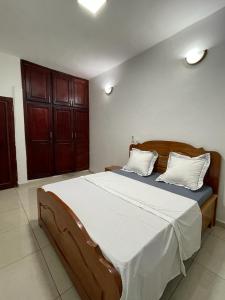 a bedroom with a large bed with two pillows at Résidence 2JGE in Douala