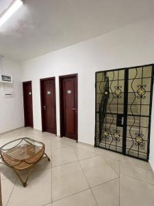 Cette chambre dispose d'une porte en verre avec une chaise. dans l'établissement Résidence 2JGE, à Douala