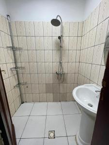 uma casa de banho com um chuveiro e um lavatório. em Résidence 2JGE em Douala