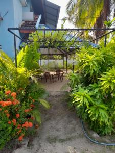 a patio with tables and chairs and plants at Batti Relax Point in Batticaloa