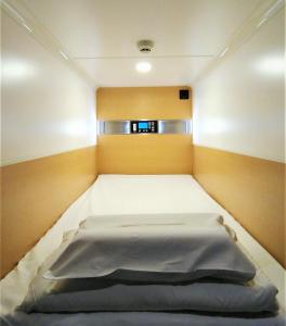 a small bed in the back of a boat at Men Only Capsule Room & Sauna, Bathhouse 男性専用サウナ&カプセル Minami Roppongi in Tokyo
