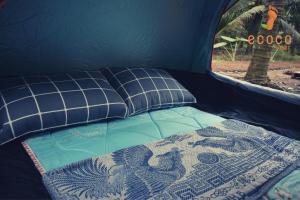 a bed in a tent with a blanket on it at Ecoco Homestay Mekong in Ben Tre