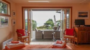 a room with a sliding glass door with a view of the ocean at Hokianga Haven in Opononi