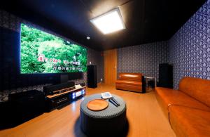 a living room with a couch and a flat screen tv at 釜之宿 天王寺 in Osaka