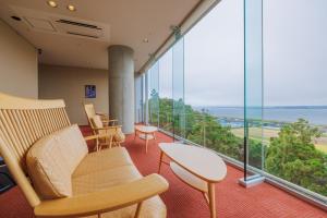 a room with chairs and a table and a large window at KAMENOI HOTEL Itako in Itako