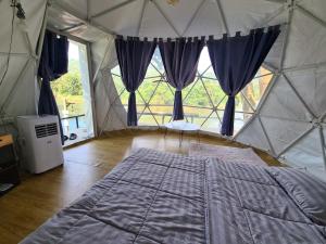 a bedroom with a bed in a canvas tent at Phuphavaree by Tahug Sai Yok in Ban Ai Hit