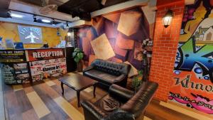 um quarto com cadeiras de couro e uma parede com graffiti em Happio - SHA Plus Certified em Banguecoque