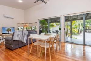 a dining room with a table and chairs and a couch at Mobys Resort 35 in Boomerang Beach