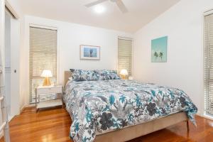 a bedroom with a bed and two windows at Mobys Resort 35 in Boomerang Beach