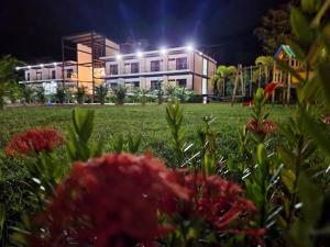 a building at night with flowers in the foreground at Hotel Capri Doradal in Doradal