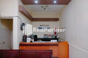 un restaurante con un cartel de socio rojo en la pared en Sawojajar Inn Mitra RedDoorz, en Malang