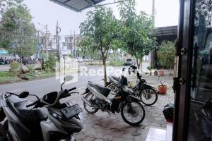 un grupo de motocicletas estacionadas al lado de una calle en Sawojajar Inn Mitra RedDoorz, en Malang