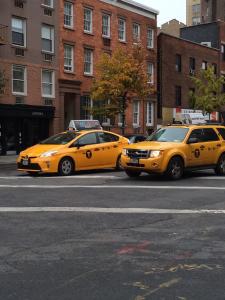 紐約的住宿－Incentra Village Hotel，停在城市街道上的两辆黄色出租车