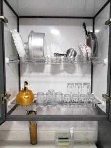 a shelf with glasses and utensils in a refrigerator at اجنحة وشاليهات شاطي الشرم شقق فندقيه خاصة Sharm Beach Suites Private hotel apartments in Yanbu