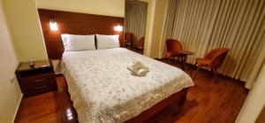 una camera d'albergo con un letto con una scatola sopra di Lembranças Hotel a Huánuco
