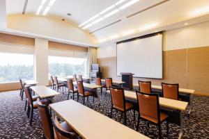 a classroom with tables and chairs and a whiteboard at KAMENOI HOTEL Itako in Itako