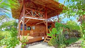 Moalboal Eco Lodge في موالبوال: كابينة خشبية فيها طاولة وكراسي