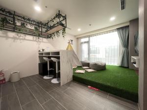 a living room with a green rug and a desk at Twelve Constellation Garden Resort in Hengchun