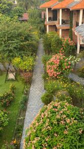 uma passarela num jardim com flores e uma casa em Chautari Garden Resort em Sauraha