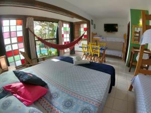 a bedroom with a bed and a living room at Pousada Canoa Azul in Garopaba