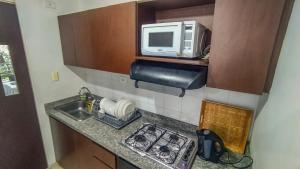 una pequeña cocina con microondas y fregadero en Apartamento 2 habitaciones en Bosque Largo - Ibagué, en Ibagué