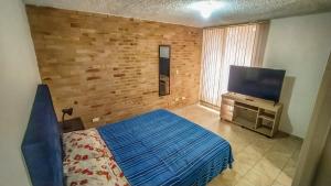 1 dormitorio con 1 cama y TV de pantalla plana en Apartamento 2 habitaciones en Bosque Largo - Ibagué, en Ibagué