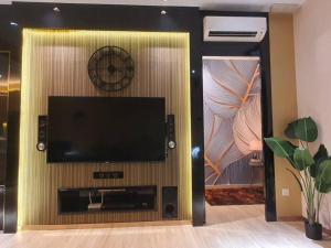 a flat screen tv on a wall with a clock at Executive Premium Comfy Home Mount Austin JB 5Pax in Johor Bahru