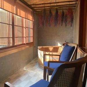 a room with a balcony with chairs and a table at MAYU Bangkok Japanese Style Hotel in Bangkok