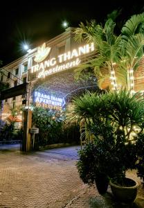 a building with a sign that says thing thanillin apartments at night at Trang Thanh Luxury Apartment in Hai Phong